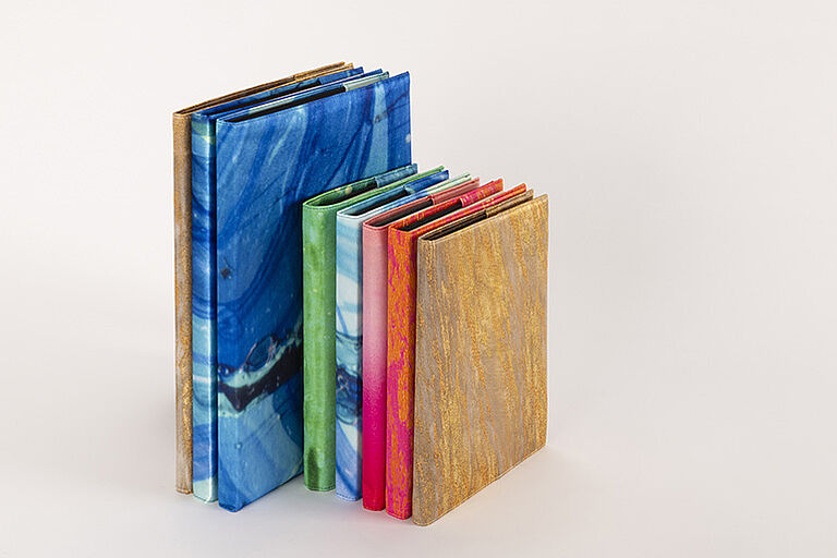 Bücher in zwei Größen mit farbigen Stoff-Umschlägen