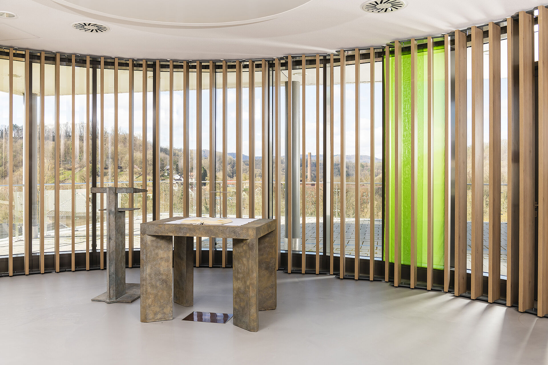 Altar, Ambo und Fensterfront mit grüner Stoffbahn Raum mit grünem Fensterparament