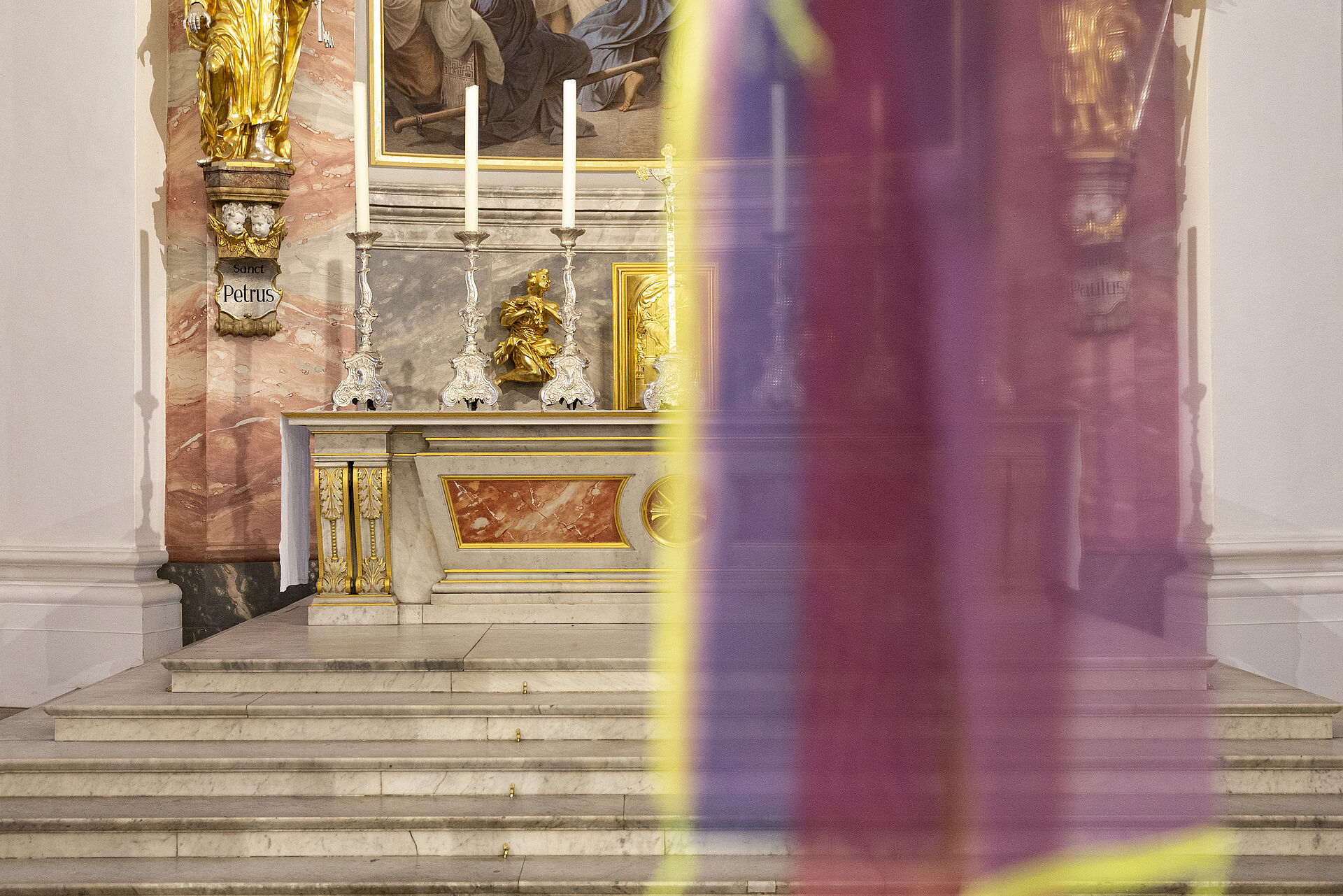 violette Stoffe mit neongrüner Kante im Kirchenraum