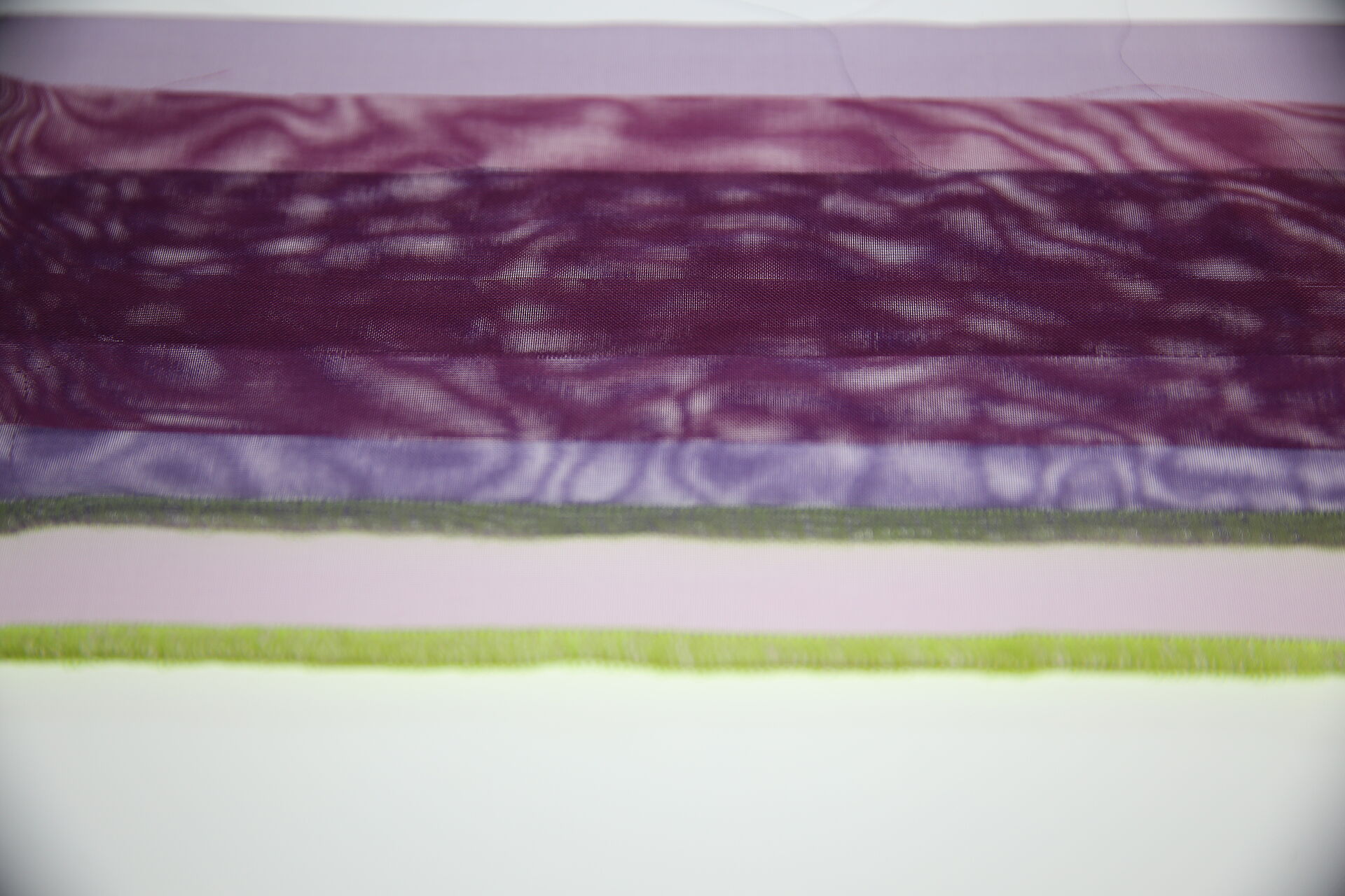 violetter Stoff mit Moireé violette Stoffe mit neongrüner Kante im Gegenlicht